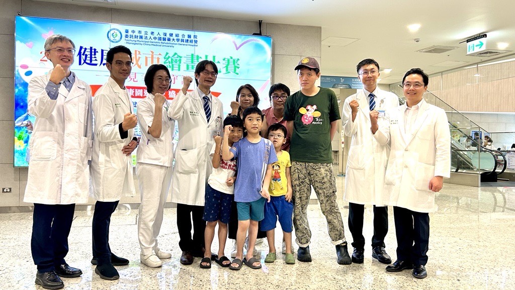 中醫大市醫院長張坤正(左四)與罕見疾病基金會中部辦事處陳虹惠主任(右五)邀請罕病家庭參與健康城市繪畫比賽。