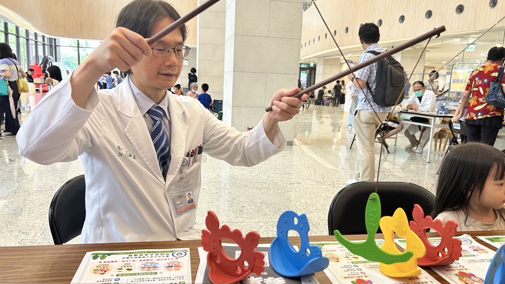 張坤正院長(右一)與小朋友一同體驗闖關遊戲，以互動傳遞健康促進理念，展現中醫大市醫親民、友善且貼近社區的醫療服務。