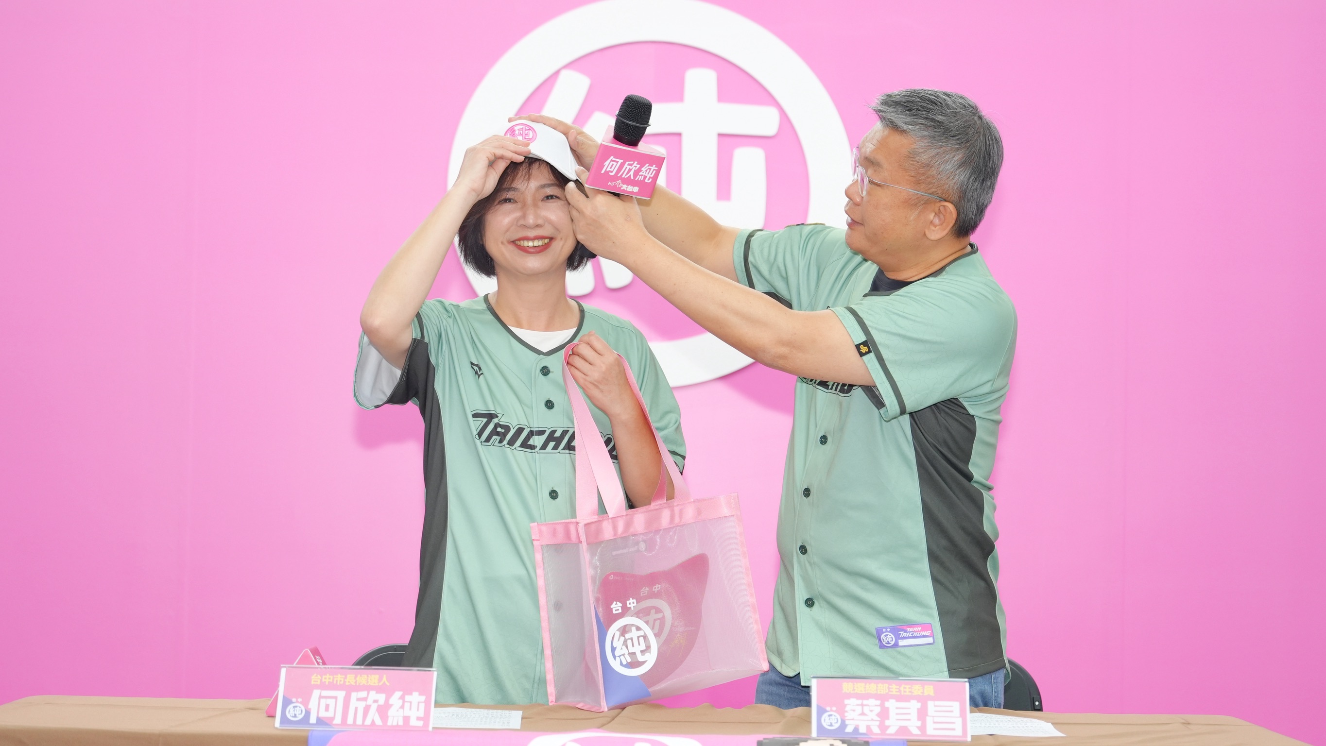 競選總部主任委員蔡其昌幫何欣純戴上最新出爐的競選球帽。