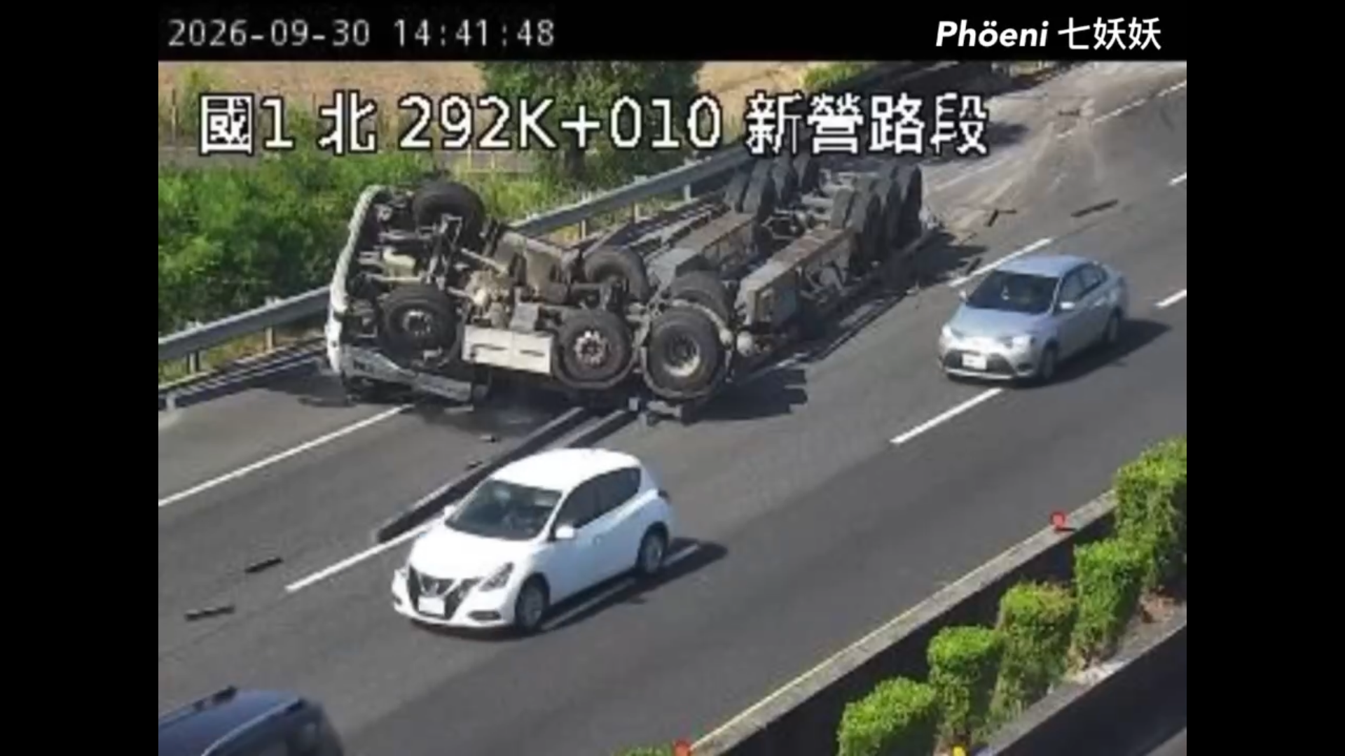 國道1號南下292公里新營路段30日下午發生拖板車翻覆事故,下午2時41分即時影像可見車輛占用中、外線。(翻攝即時路況影像)