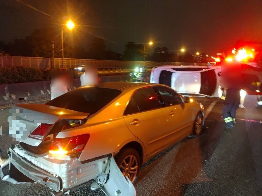 國道1號高雄路段14日晚間發生3車連環撞,其中一輛自小客車側翻橫躺車道,救援人員到場處理。(翻攝畫面)