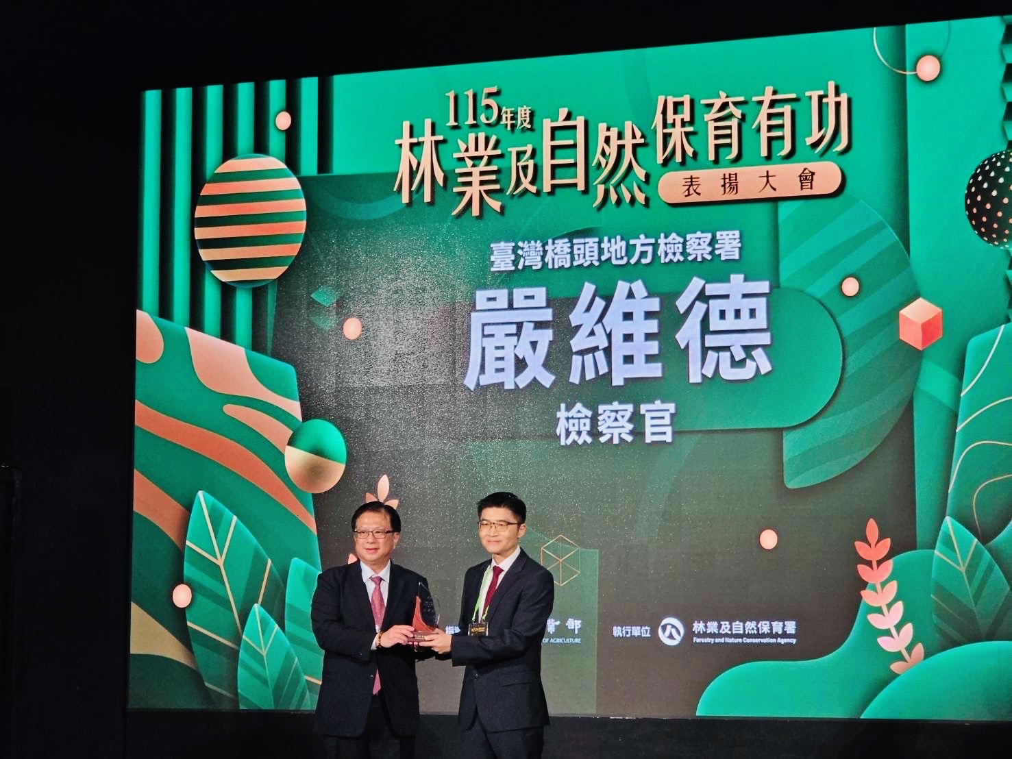 橋頭地檢署檢察官嚴維德（右）長期投入重大環境犯罪查緝，榮獲農業部「115年度林業及自然保育有功人員」獎項，出席表揚大會接受肯定。（圖／橋頭地檢署提供）