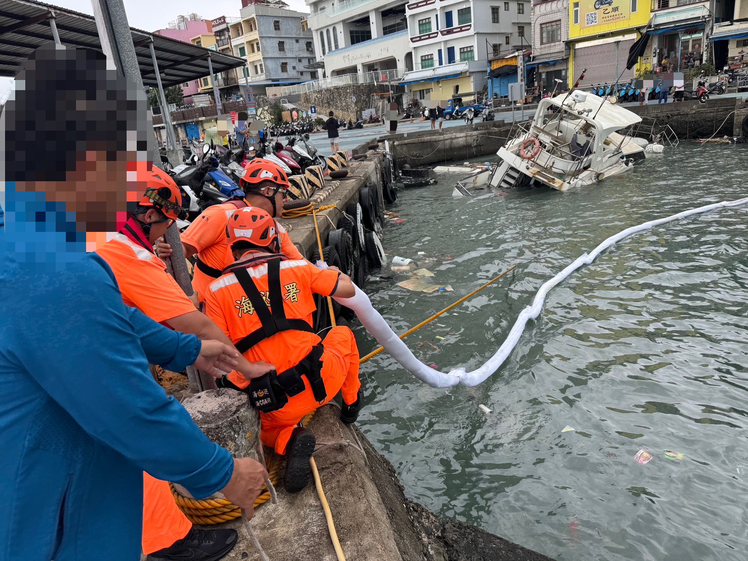 薔琵颱風外圍環流帶來強烈湧浪,屏東小琉球白沙漁港一艘枋寮籍遊艇疑因繫纜斷裂、船體進水,導致船身傾斜座底,周邊水域更出現疑似廢油水浮膜,海巡人員緊急布設吸油棉索及吸油棉片,防止油污擴散。(海巡署提供)