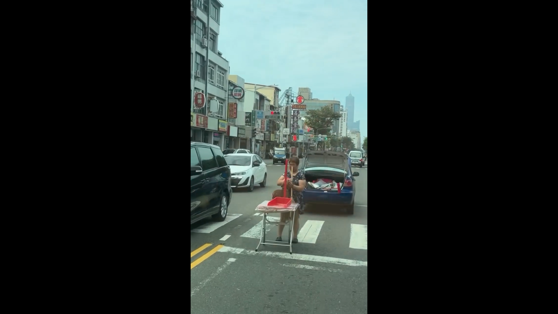 高雄三多路婦人「路中央擺桌」像在作法！轎車拋錨沒警示牌　畚箕、掃帚全搬出來