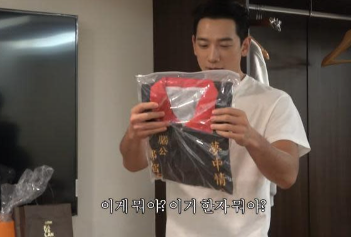 Rain穿上粉絲送的宮廟背心。（圖／翻攝Rain YouTube）