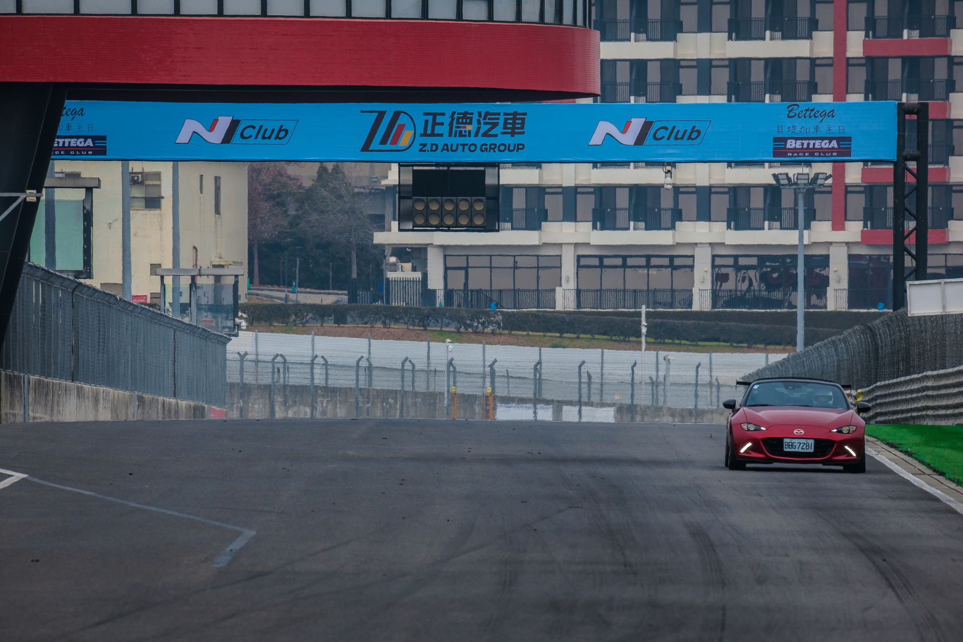 賽道直線段畫面，車輛於合法、封閉的賽車場環境中進行體驗，強調將速度放在正確場域，與一般道路駕駛明確區隔。