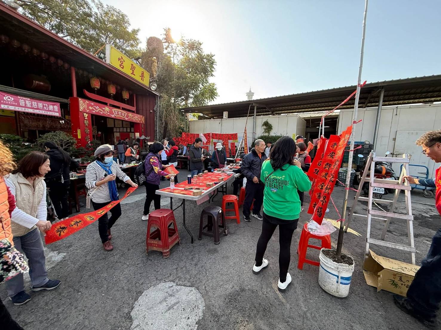 普聖宮廟埕化身公益與文化交流空間，書法揮毫、春聯贈送與關懷行動同步進行，延續宮方長期關注弱勢群族的初心，讓年節更添溫度。