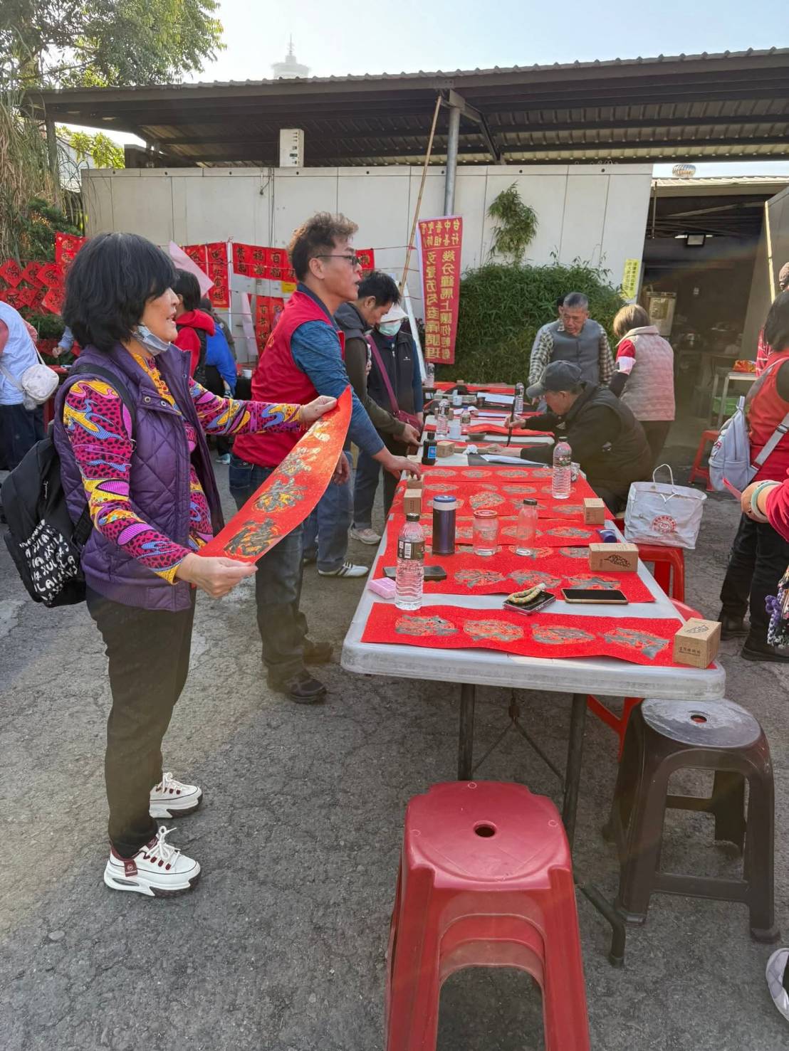 書法老師現場揮毫，民眾排隊領取春聯，紅紙墨香交織出濃厚年節氛圍，普聖宮透過文化活動，讓關懷自然走進日常生活。