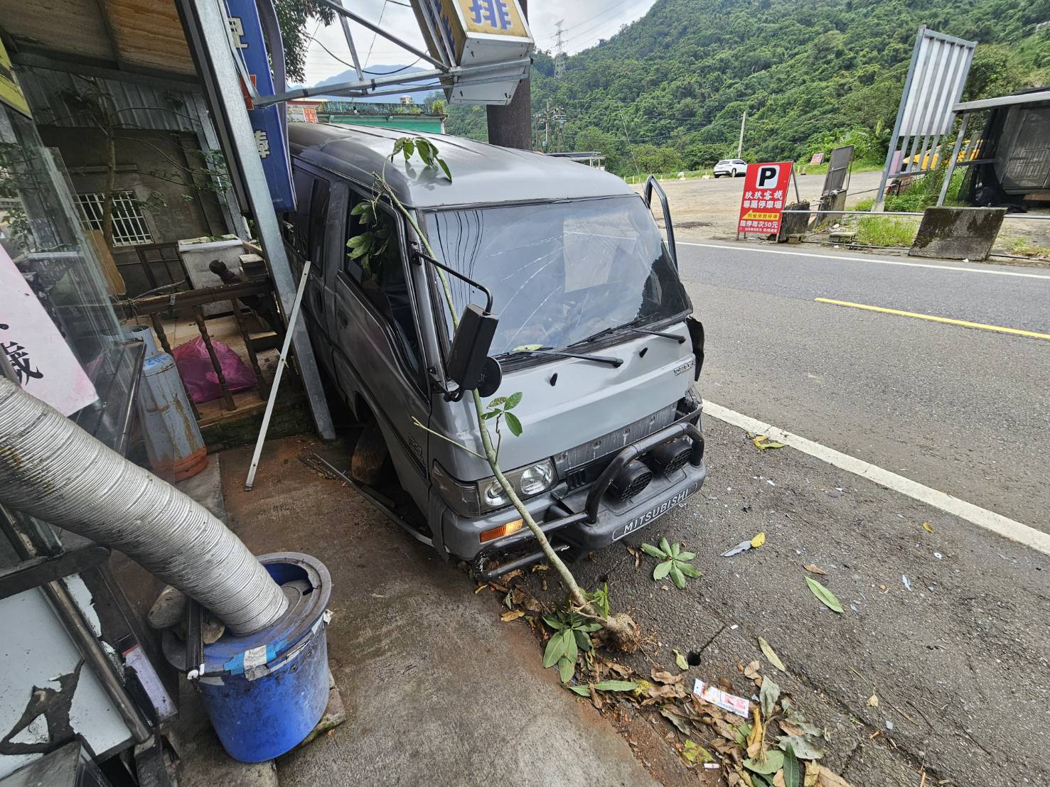 ▲53歲崔姓男子駕駛自用小客貨車，準備返回安坑住家時，行經路段突見「黑影」竄出，急踩煞車後車輛失控，猛烈撞上路邊招牌與鐵欄杆，一度受困車內。（翻攝畫面）