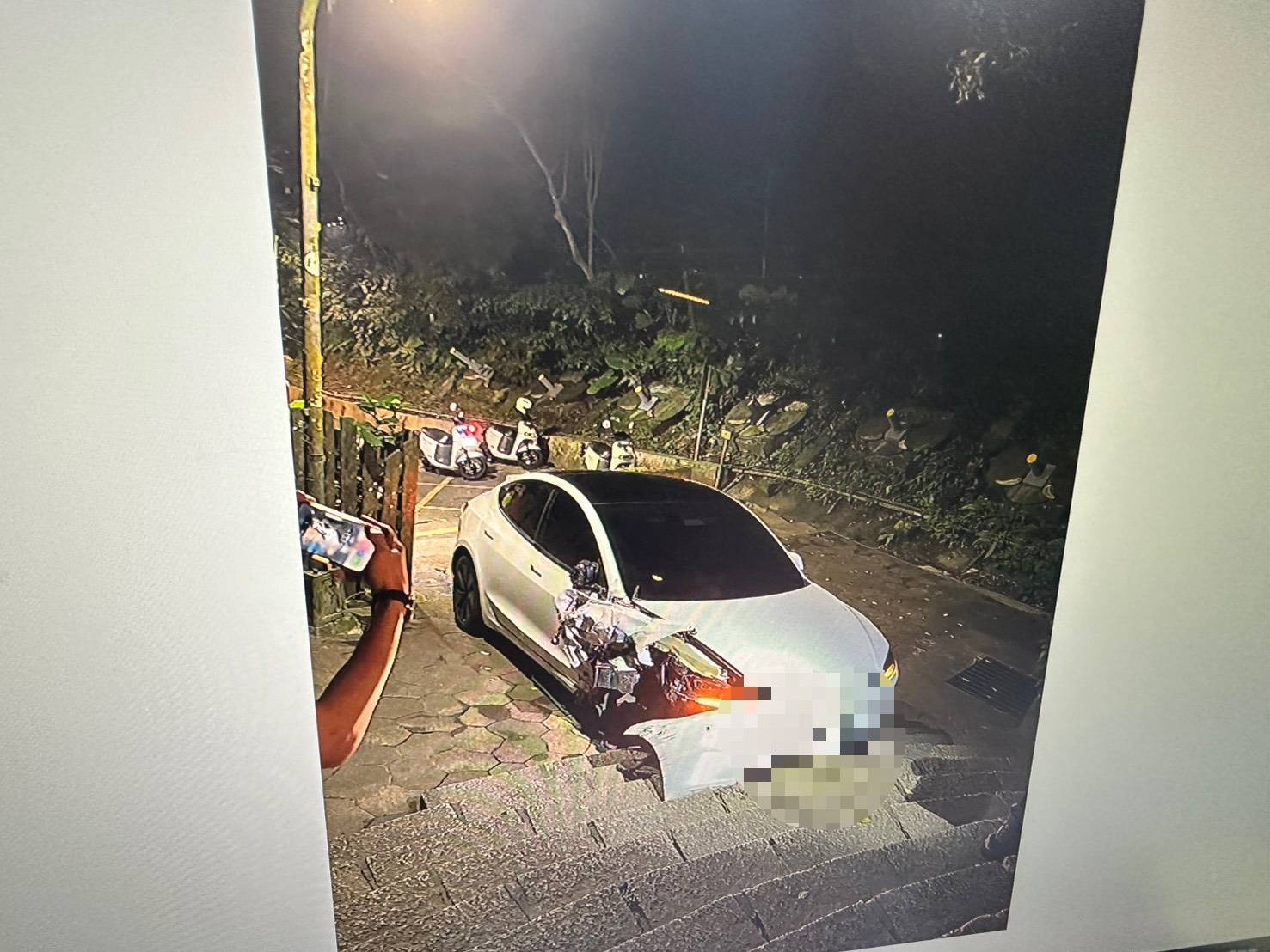 ▲蕭姓男子最終將僅剩3顆輪胎的特斯拉開上象山步道口階梯才棄車離去。（翻攝畫面）