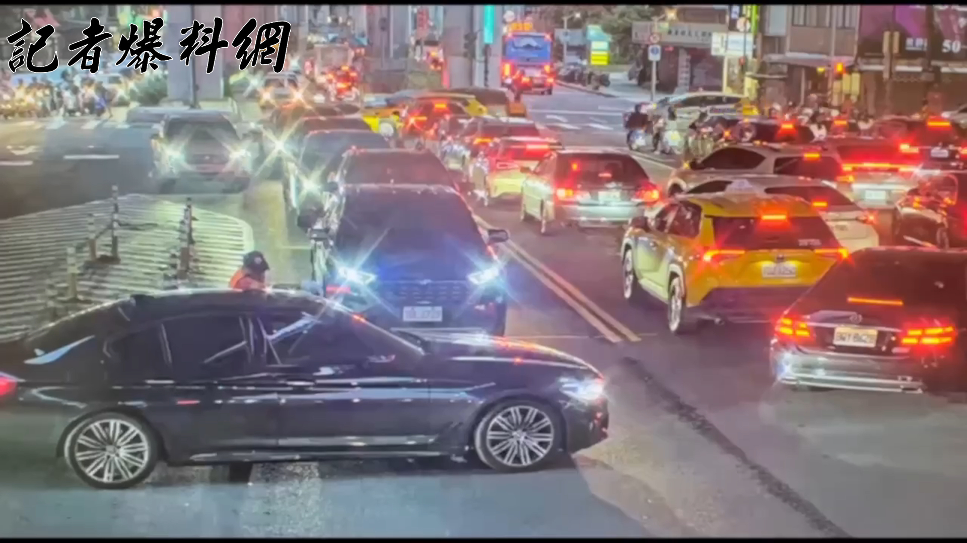 ▲朱男駕駛黑色BMW自小客車，由建國南路北上準備左轉西向高架道路，碰上路口號誌轉紅燈，鄭姓義交見狀欲引導他移動至槽化線以維持路口淨空。未料朱男誤解指令，車輛仍向前駛直接卡在路口中央。（翻攝畫面）