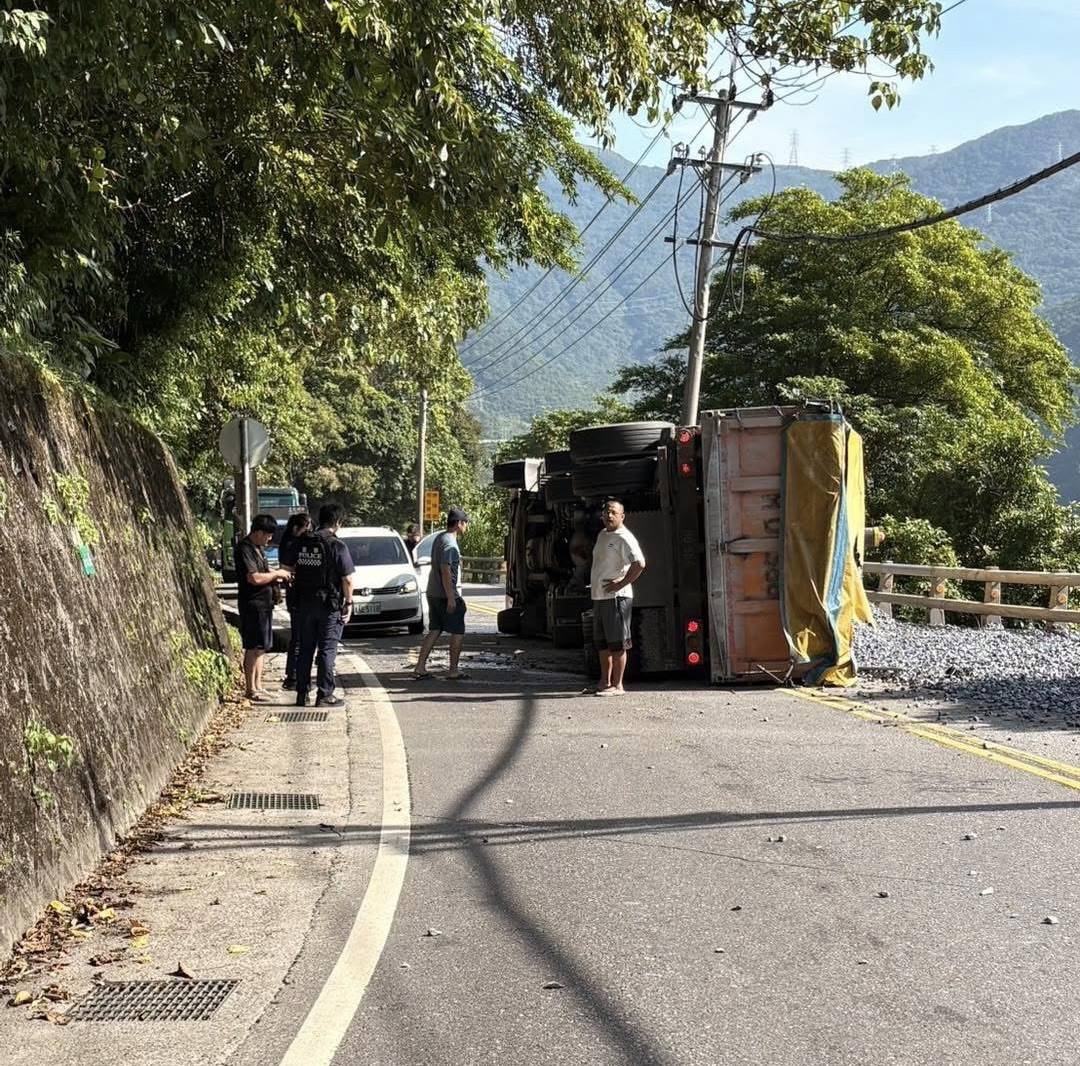 ▲曳引車疑因輪胎打滑，行經彎道時瞬間失控側翻，車斗內載運的砂石傾瀉一地，波及對向行駛而來的小客車，導致小客車擋風玻璃被碎石擊中。（翻攝自《記者爆料網》群組）