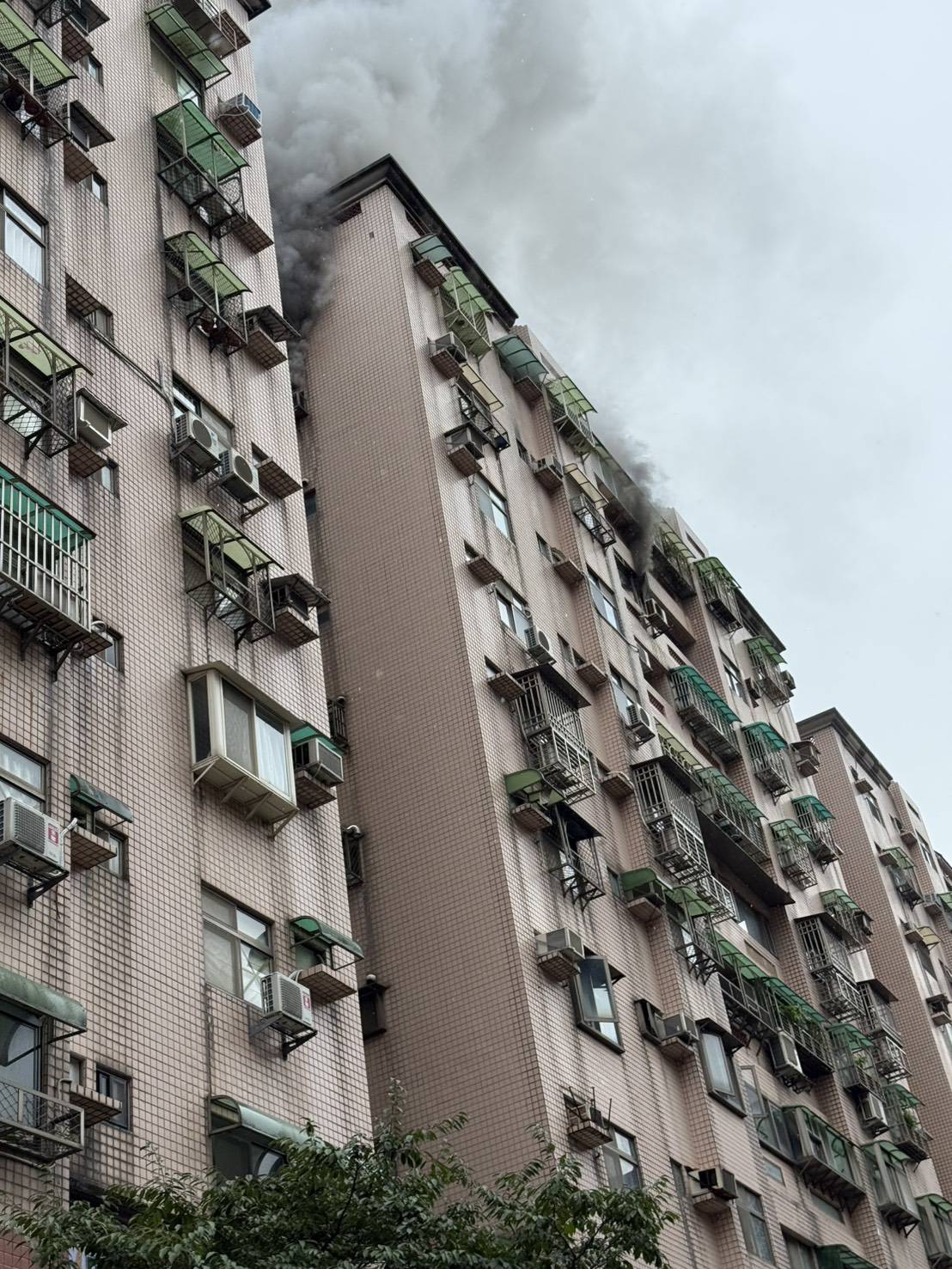 ▲新北市淡水區新興街1處社區大樓，今（21）日上午9時許，9樓1處住宅房間突然竄出火煙。（翻攝畫面）