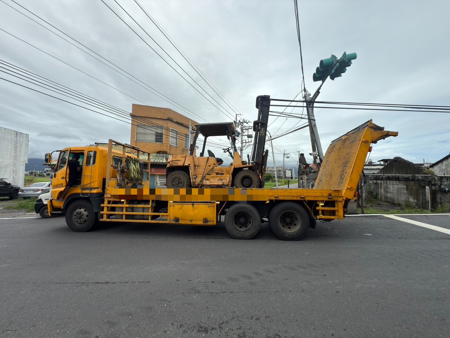 ▲42歲林姓男子駕駛大貨車行經礁溪鄉大塭路、大福路二段路口時，車上載運的推高機升降軌不慎勾住電線。（翻攝畫面）