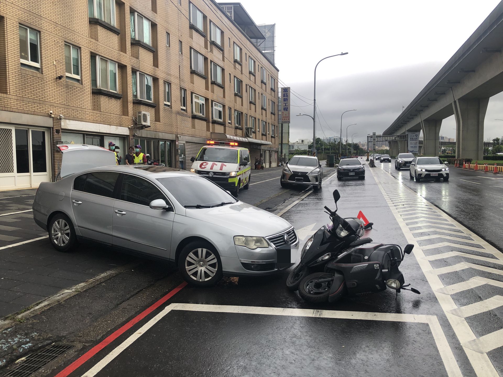 ▲59歲林姓女駕駛將車停靠路邊擺放物品時，疑似未將車輛確實排入P檔且未拉手煞車，導致車輛突然滑動，撞上當時正在停等紅燈的33歲楊姓男機車騎士及28歲曾姓女機車騎士。(翻攝畫面)