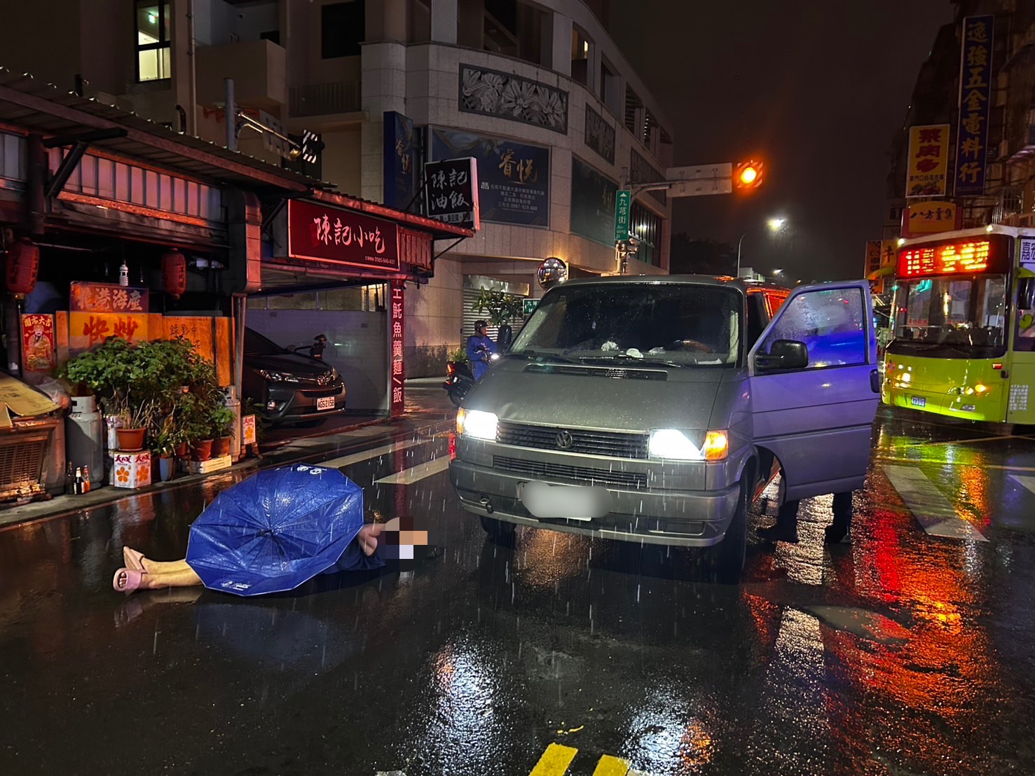 ▲65歲閻姓婦人撐傘行經長安街、九芎街口斑馬線時，遭1輛左轉廂型車撞倒在地，倒臥濕滑路面無力起身。（翻攝畫面）