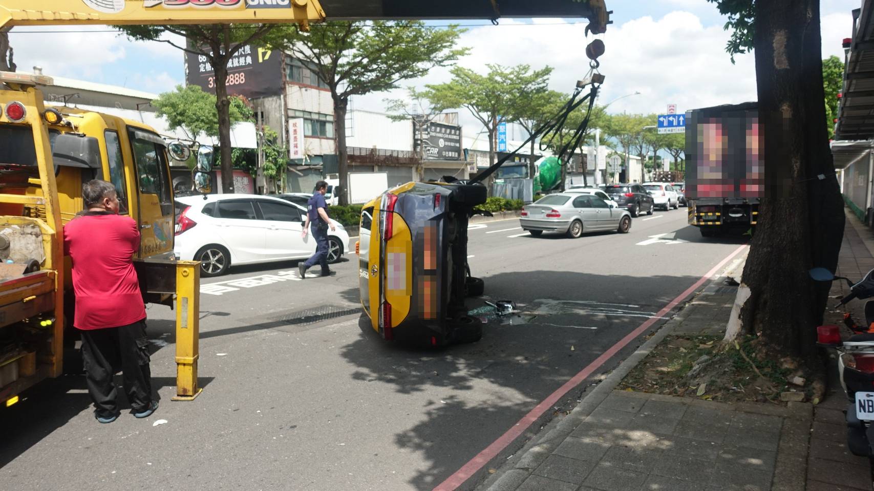 ▲碰撞導致計程車失控，向右偏移後擦撞到路旁行道樹，隨後側翻在路中。（翻攝畫面）