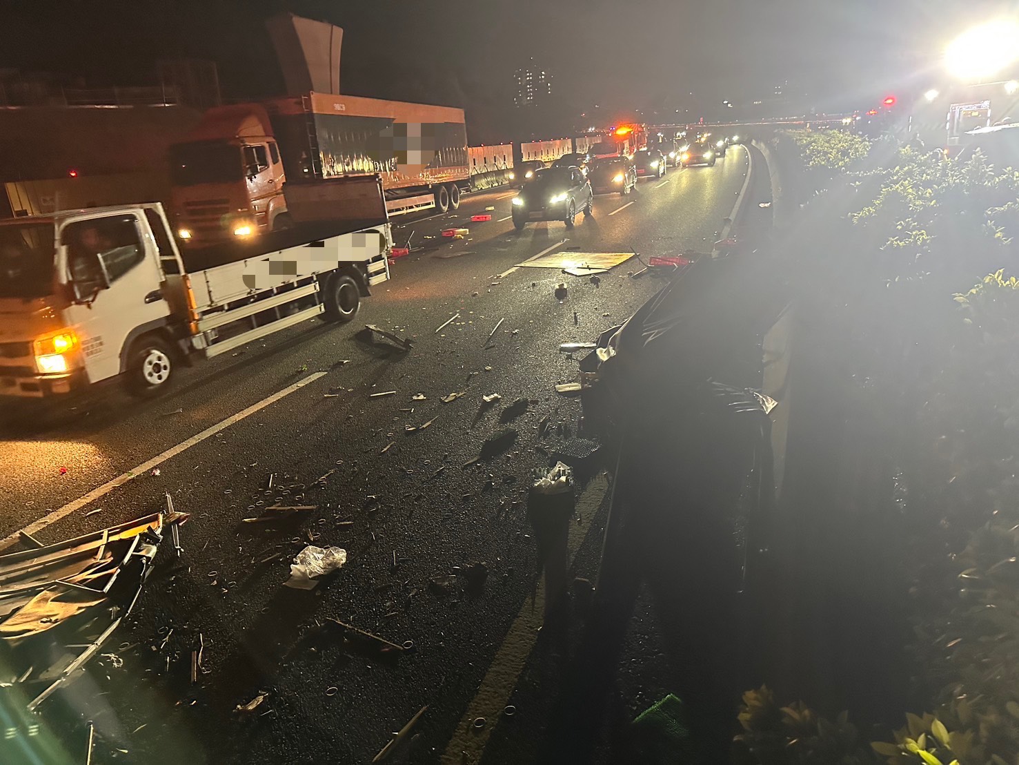 小貨車碰撞後翻覆，車殼零件碎片四散飛濺，波及過路車輛也造成交通回堵。