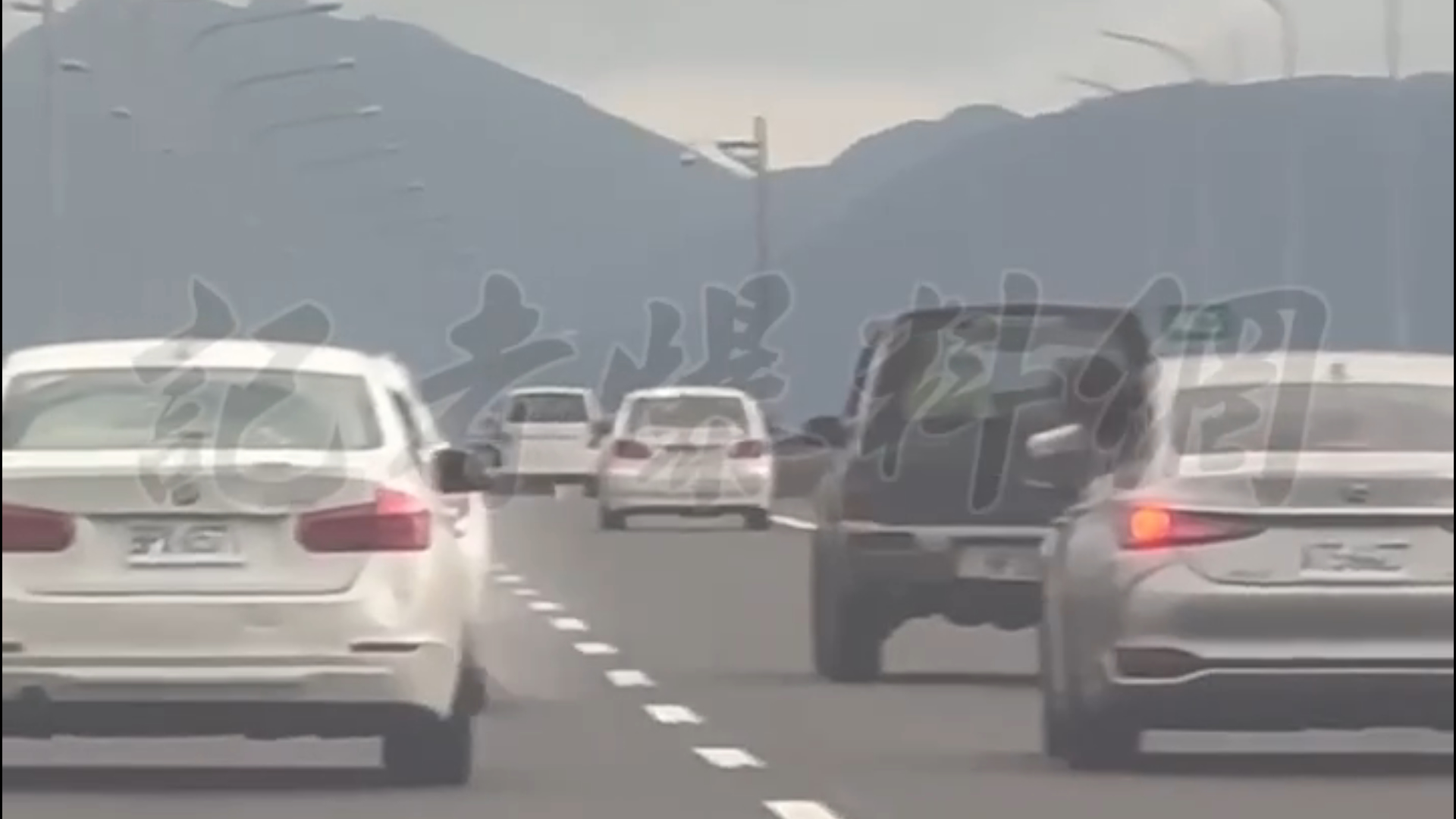 銀色凌志左後座的1名女子先是搖下車窗，將半個身體探出窗外，朝旁邊的白色BMW丟擲水球。