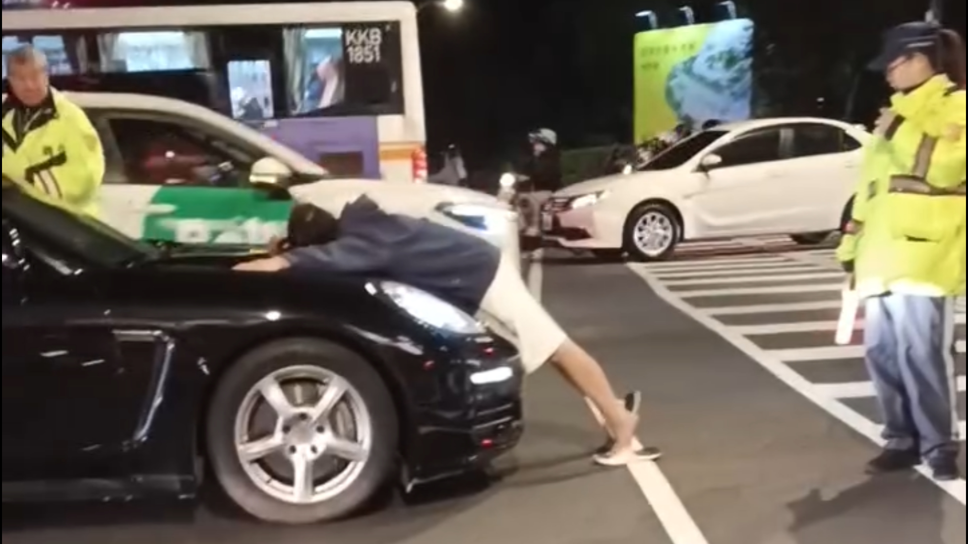 新北市版橋區1名男子無視交通號誌，闖紅燈穿越馬路後，擋下1輛行駛中的保時捷，隨後更直接趴上保時捷的引擎蓋，做出不斷抖動下體狂頂車頭的詭異動作。畫面翻攝自Threads@zyx._.116