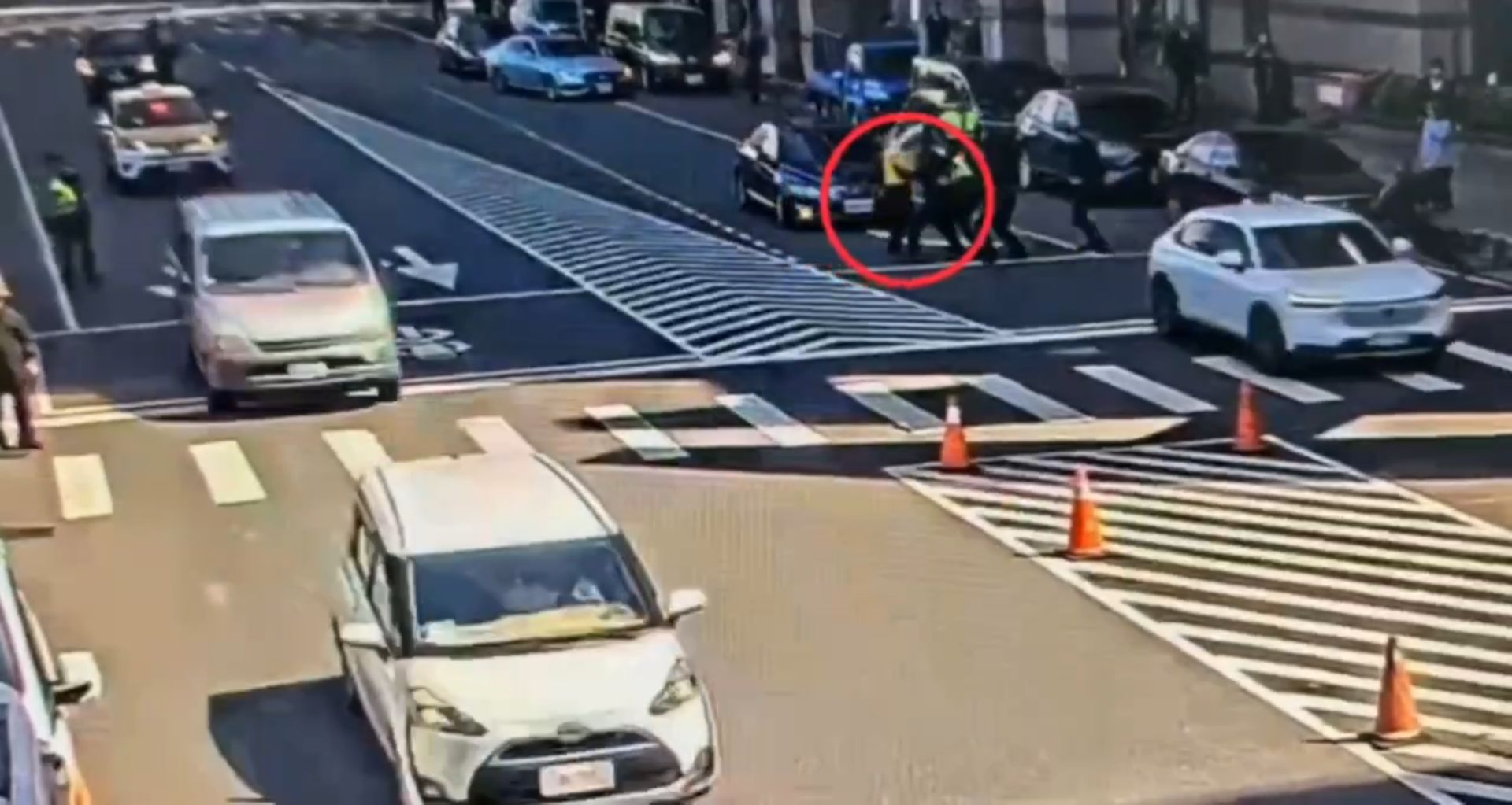 游智彬不僅違規穿越馬路，還企圖朝大樓丟擲雞蛋滋事，卻「暴投」意外砸中一旁的攝影記者。