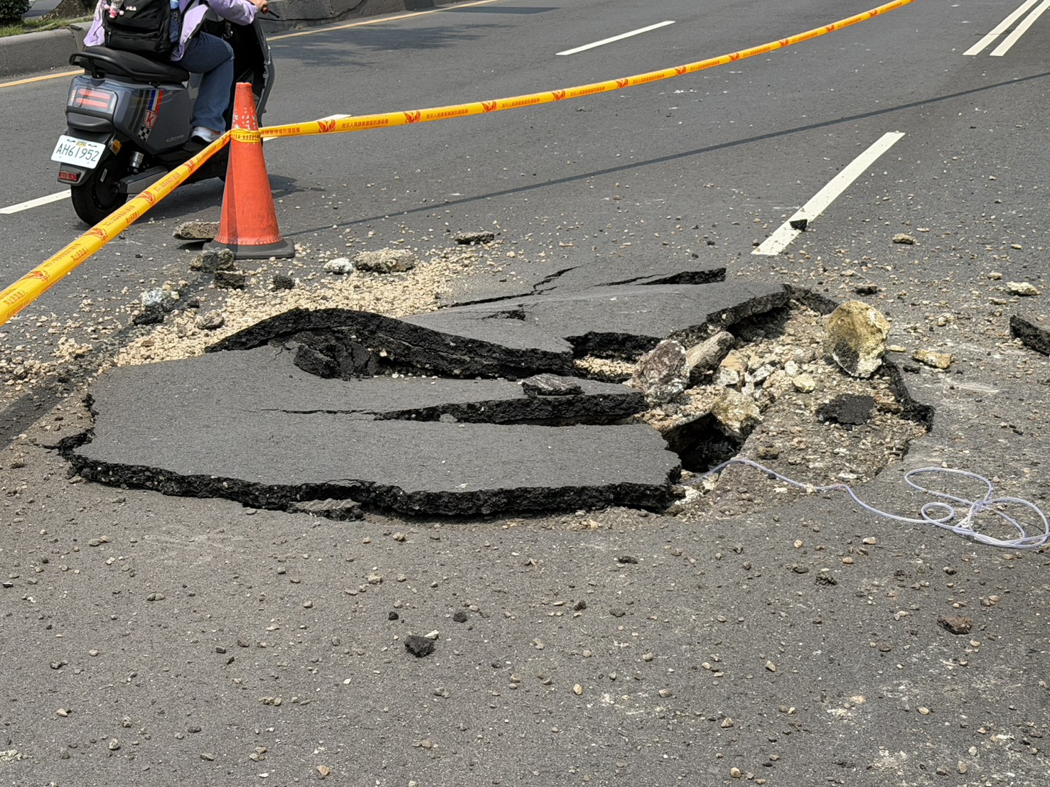 新北市板橋區縣民大道往華翠大橋上橋處，今（14）日中午12時許有民眾聽聞巨大聲響，外出查看驚見柏油路面不明原因「炸開」隆起破裂，碎石塊散落占據車道。
