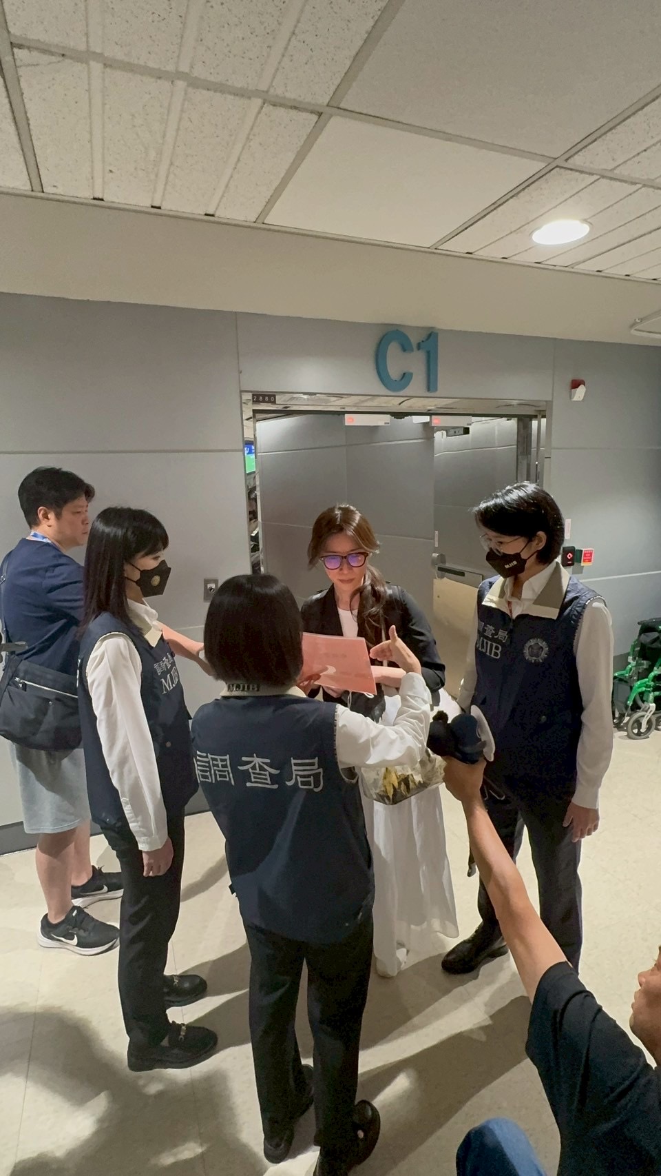 ▲網紅「貴婦奈奈」涉嫌吸金10億元，逃亡海外長達7年，今被調查局人員押解回台，在機場上銬，被帶往地檢署偵訊。（圖／調查局提供）