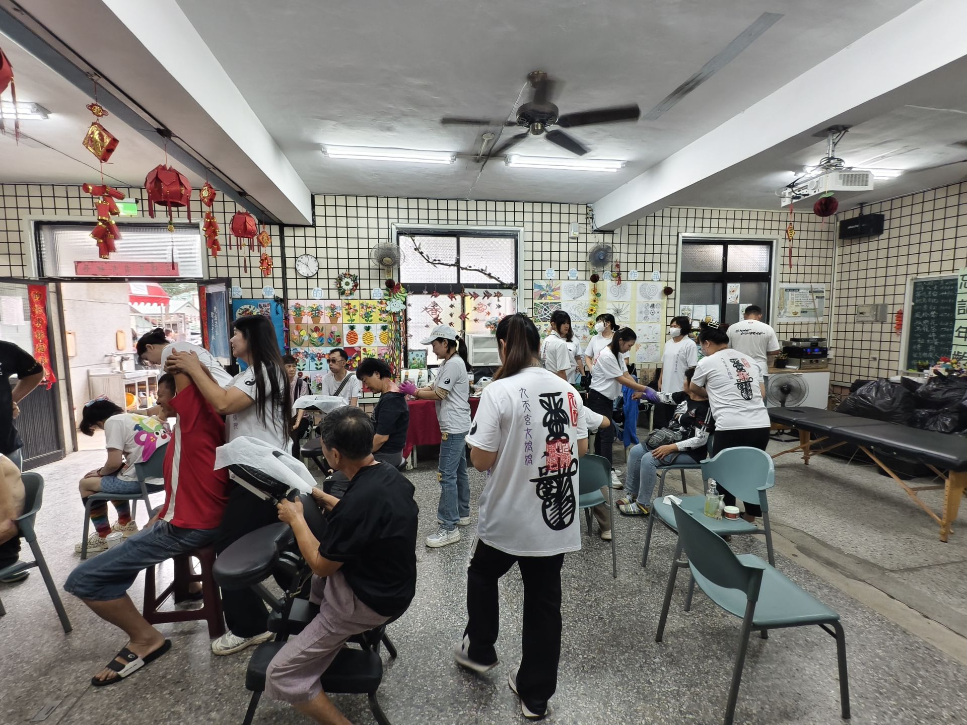 志工團隊協助物資發放與義剪服務與免費義診與脊椎調理，現場氣氛溫馨熱鬧。