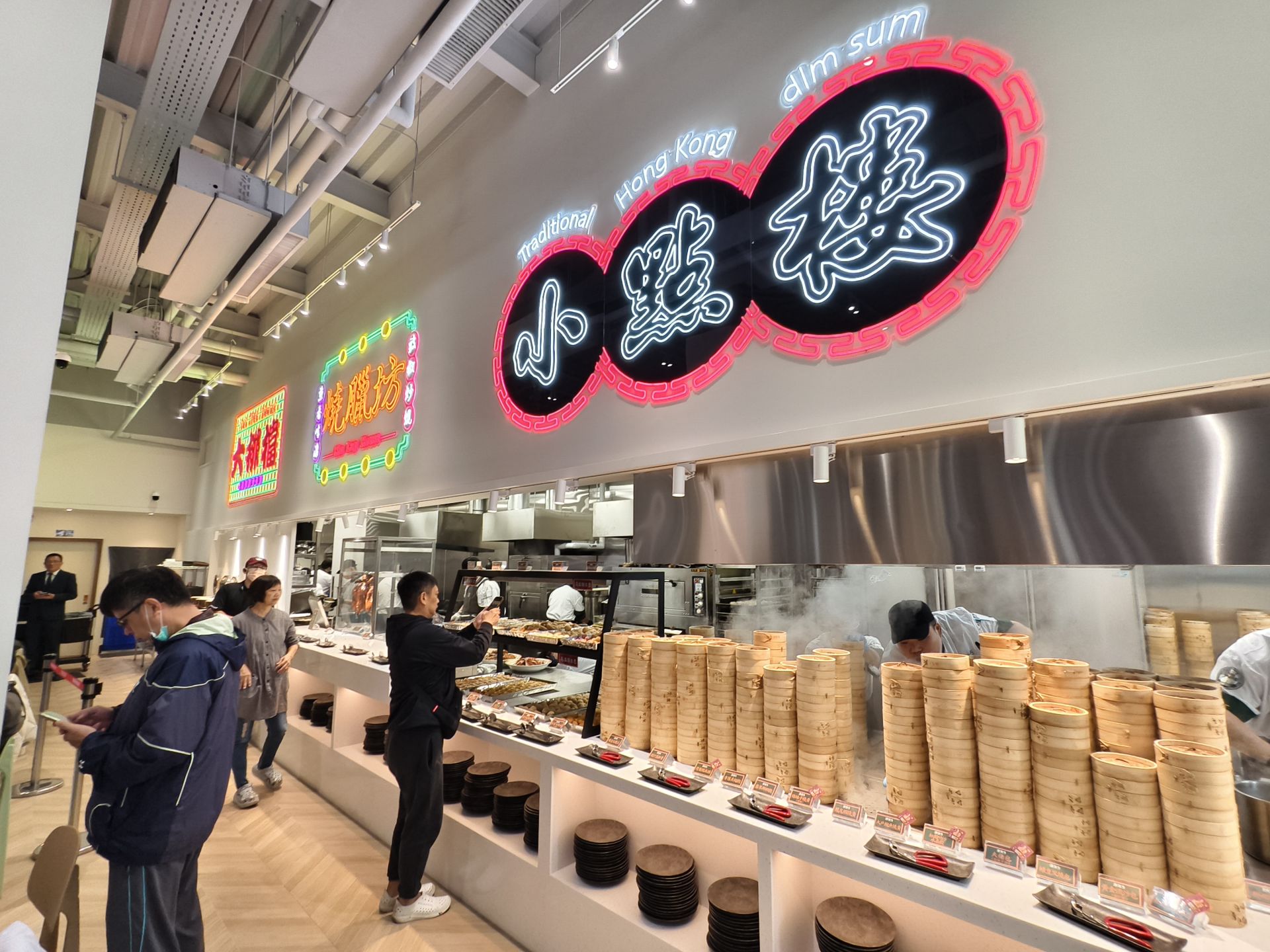 「港佬大」港式百匯吃到飽一樓用餐區人潮絡繹，蒸籠、燒臘、點心區全線開放，呈現濃厚港味與熱鬧活力，開幕首日吸引民眾排隊體驗。