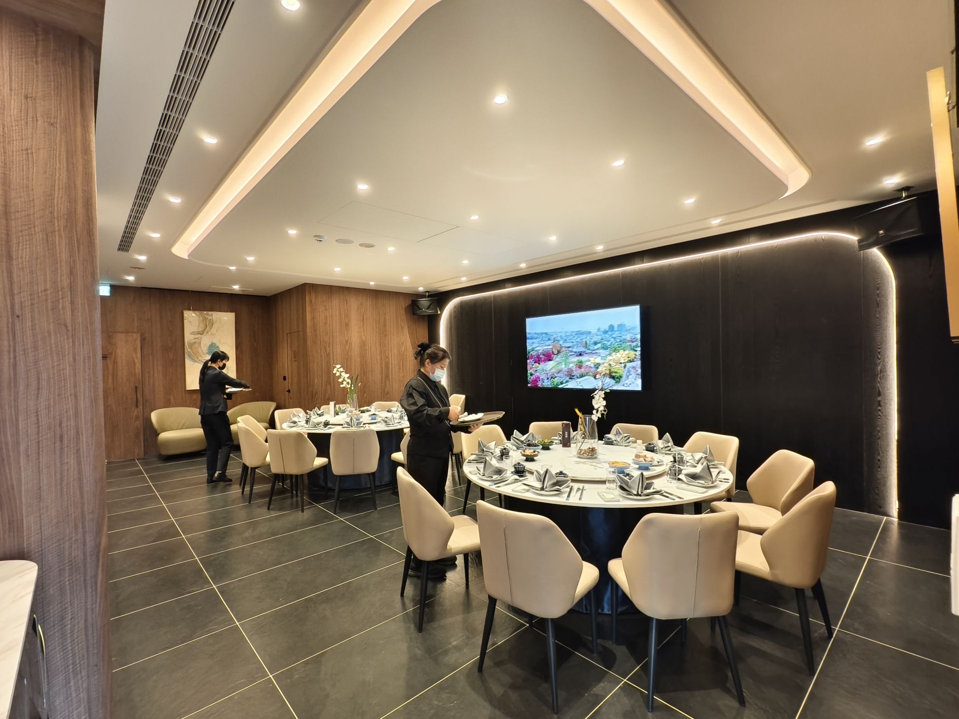 潮港城二樓全新品牌「潮膳閣」打造獨立式高隱私包廂，每間均配備 KTV 與精緻宴席桌位，服務人員於開幕日忙碌備餐，呈現尊榮質感的用餐氛圍。