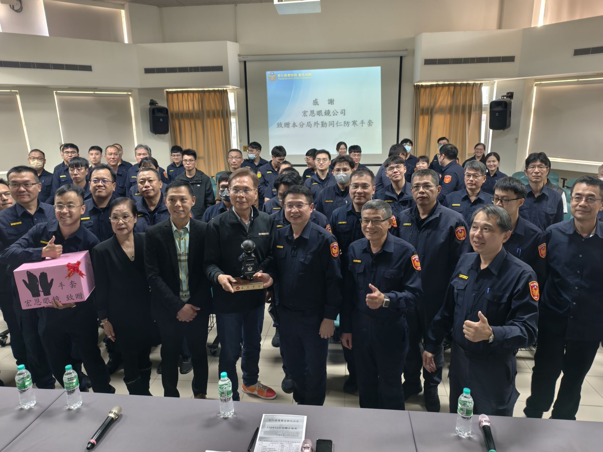 彰化市宏恩眼鏡捐贈禦寒「特殊戰略手套」守護基層警力，彰化分局局長林英煌（前排右）、宏恩眼鏡創辦人陳孫武（前排中）及分局顧問呂國郎（前排左）與分局員警合影，感謝企業暖心支持第一線執勤安全。