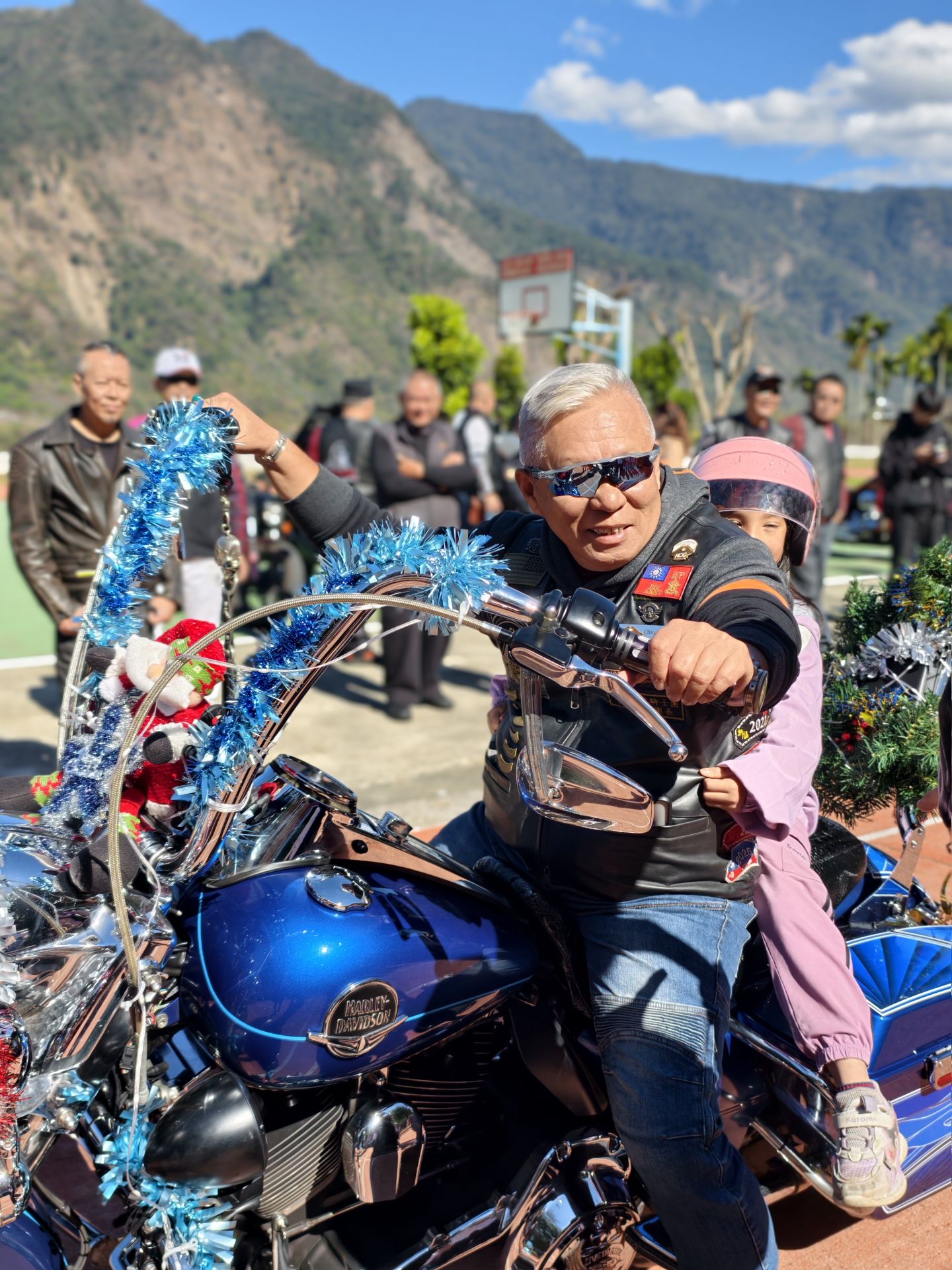 重型機車騎士載著學童體驗重機，車輛以聖誕裝飾點綴，在安全防護下進行互動，讓孩子近距離感受節慶氣氛與陪伴溫度。