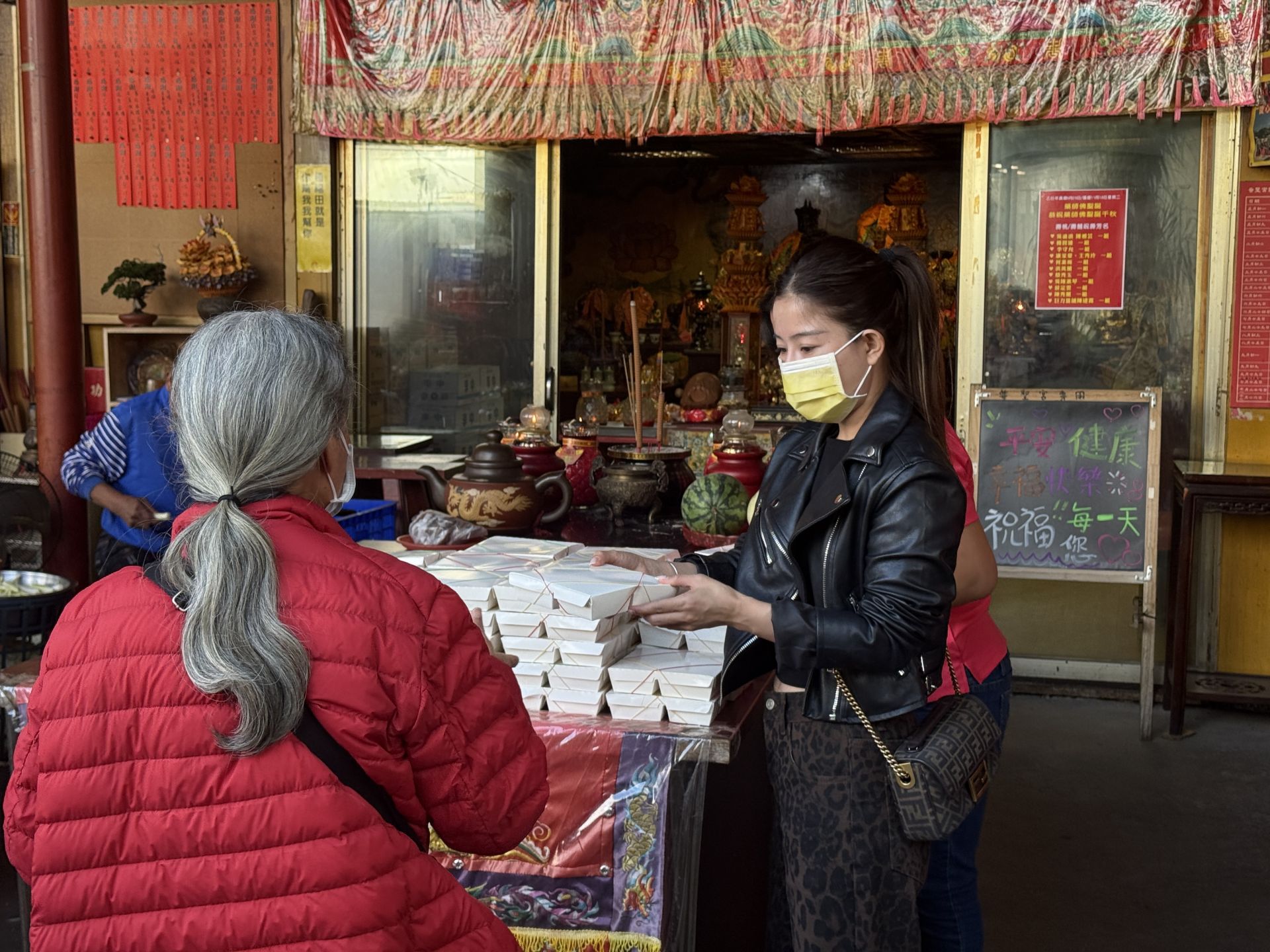 每到發放時間，志工便在普聖宮廟前協助領取，確保長者與行動較不便者都能順利拿到便當。
