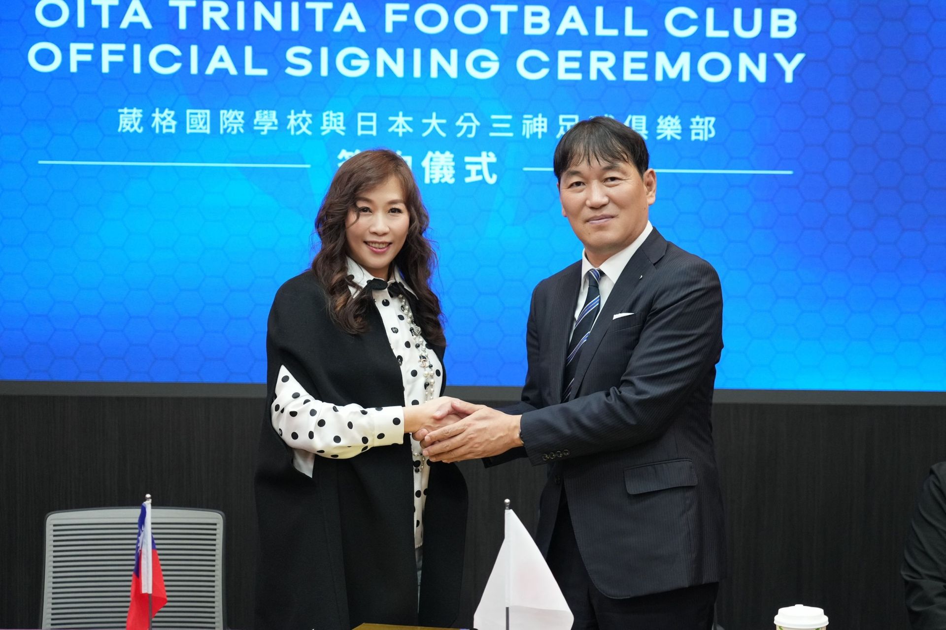 葳格國際學校執行董事吳菀庭（左）與大分三神足球俱樂部社長小澤正風（右）握手致意，象徵合作正式啟動。