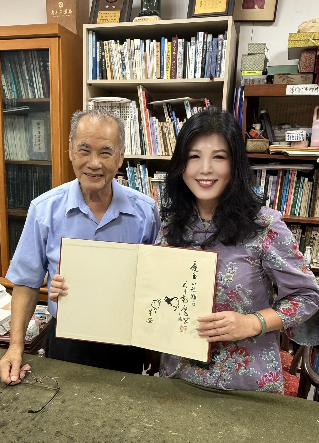 李穀摩老師在畫冊扉頁親繪雙鳥並題字，寓意吉祥與傳承，並贈予廖庭玉理事長留念。