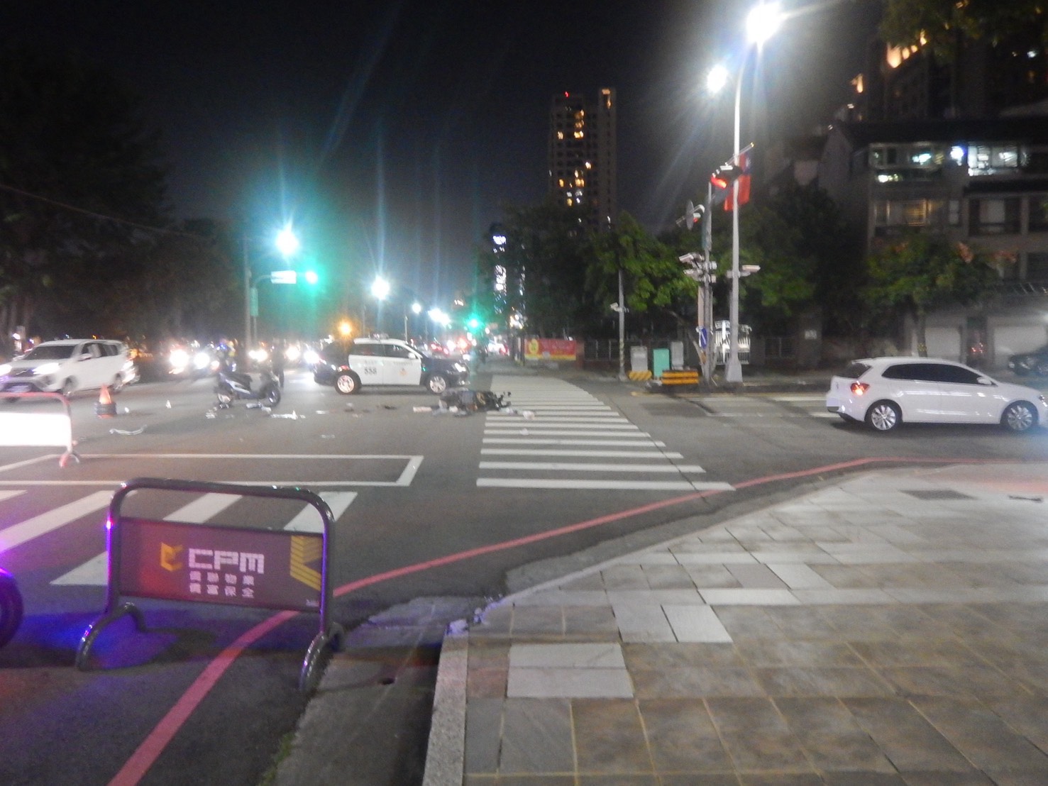 普重機車與相關物件散落路面,警方於現場勘查事故痕跡。