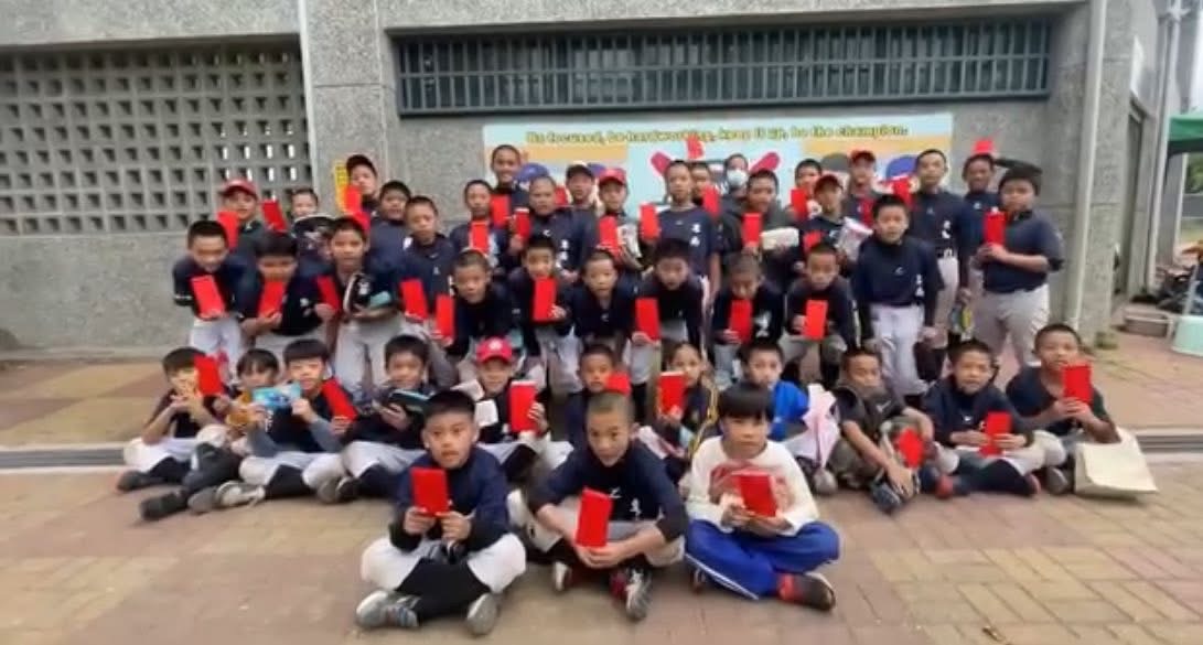 不同年齡層的棒球小將開心展示收到的紅包，象徵年節祝福與社會各界的溫暖支持。