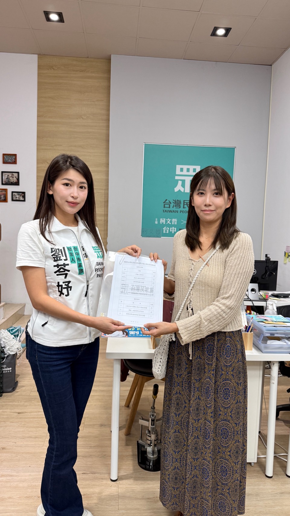 劉芩妤與民眾代表一同展示完成的登記資料,象徵地方參與與民主互動。