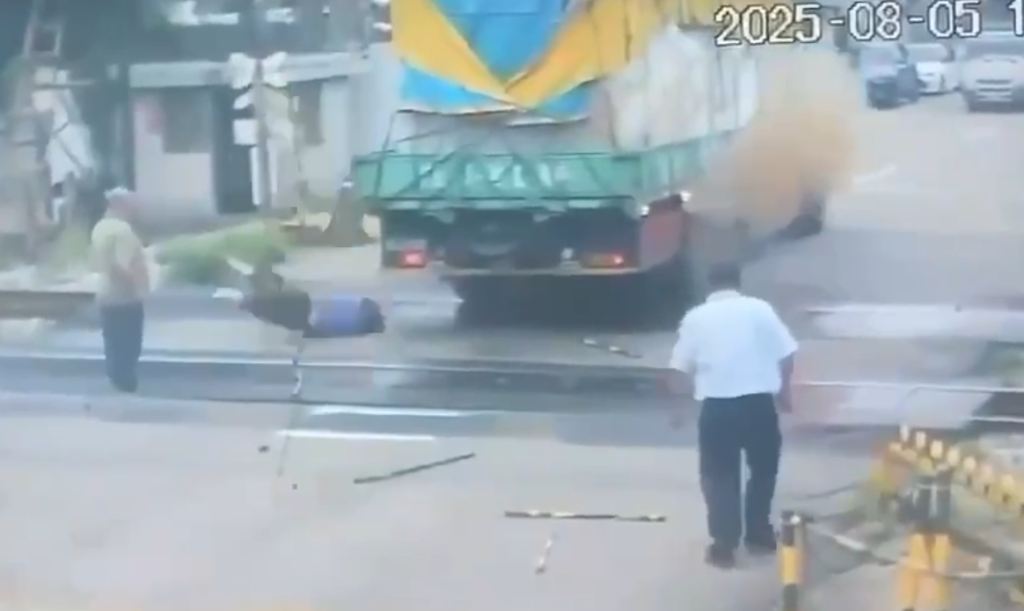 驚悚畫面曝光！貨車經過平交道載物超高卡住電纜線　司機爬車頂處理觸電墜地