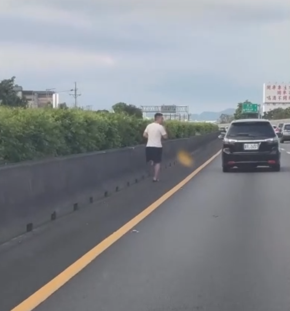 國道1號內側路肩穿拖鞋拿手機跑步！　警方將開罰