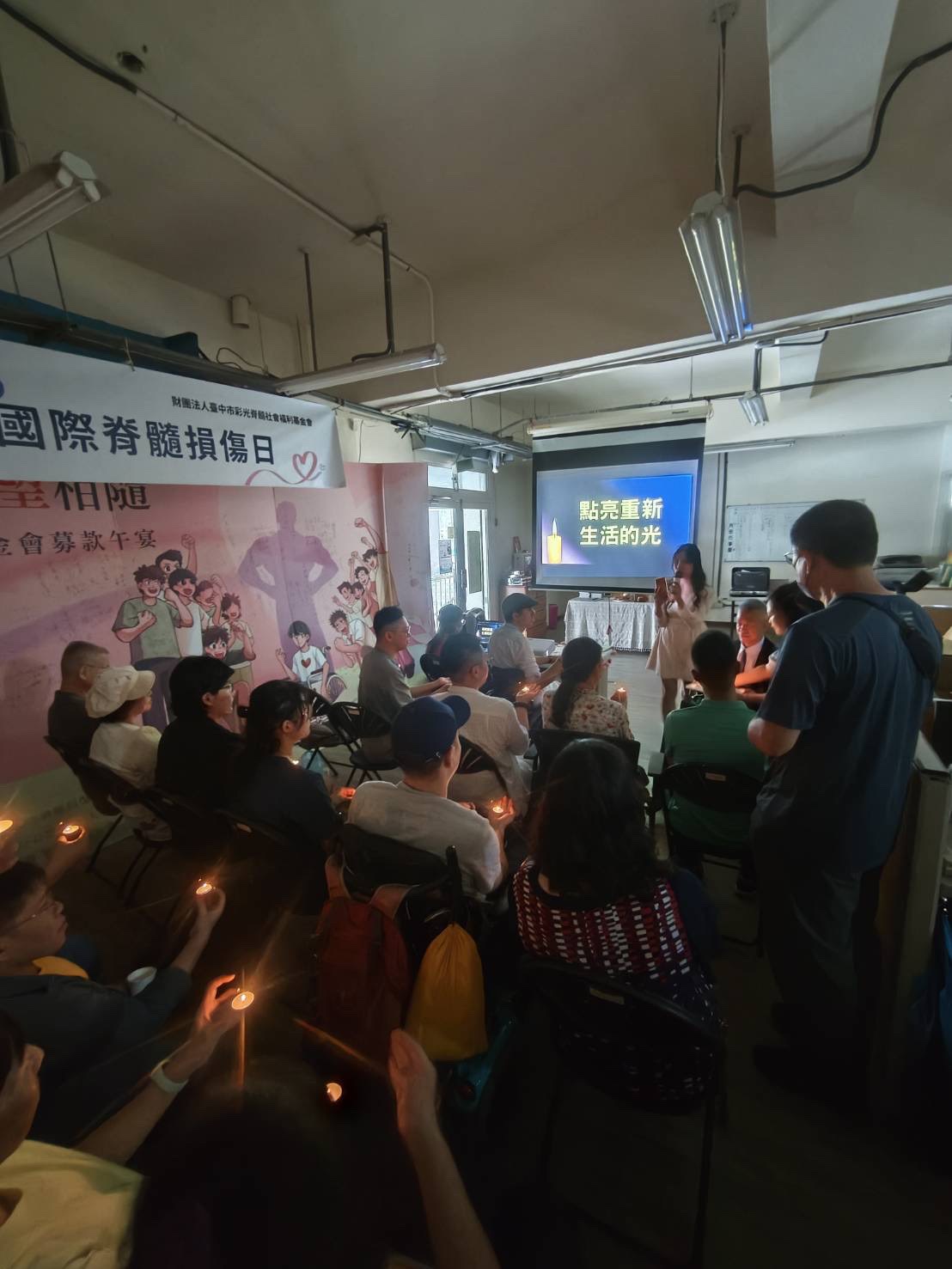 ▲ 活動現場，從董事長手中傳遞過來的微亮燭火，象徵著希望傳承。（照片 / 基金會提供）。