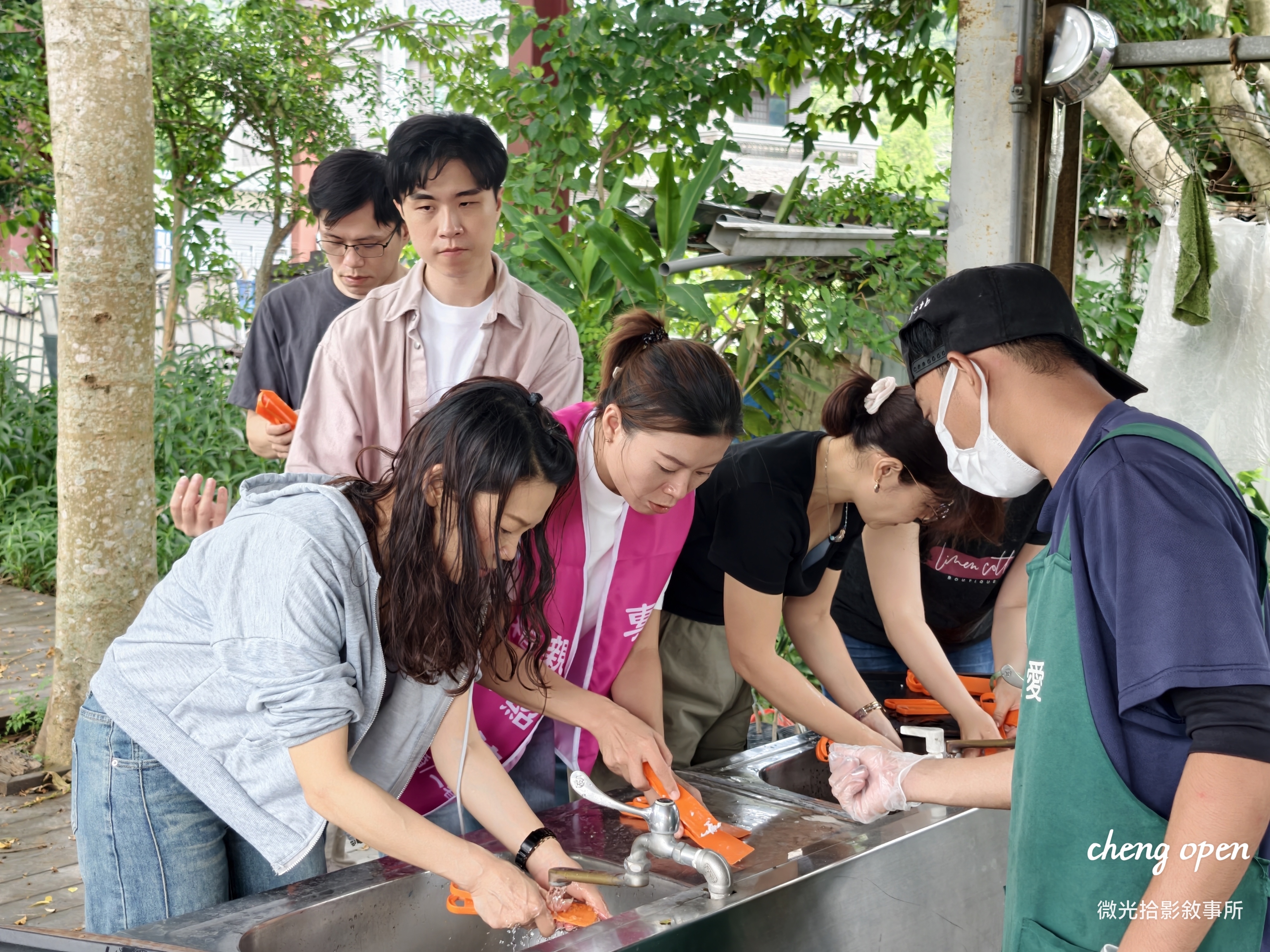 ▲ 青年志工們在園區水槽前共同清洗用具與器皿，以踏實勞動實踐公益服務精神/ 微光拾影敘事所 攝
