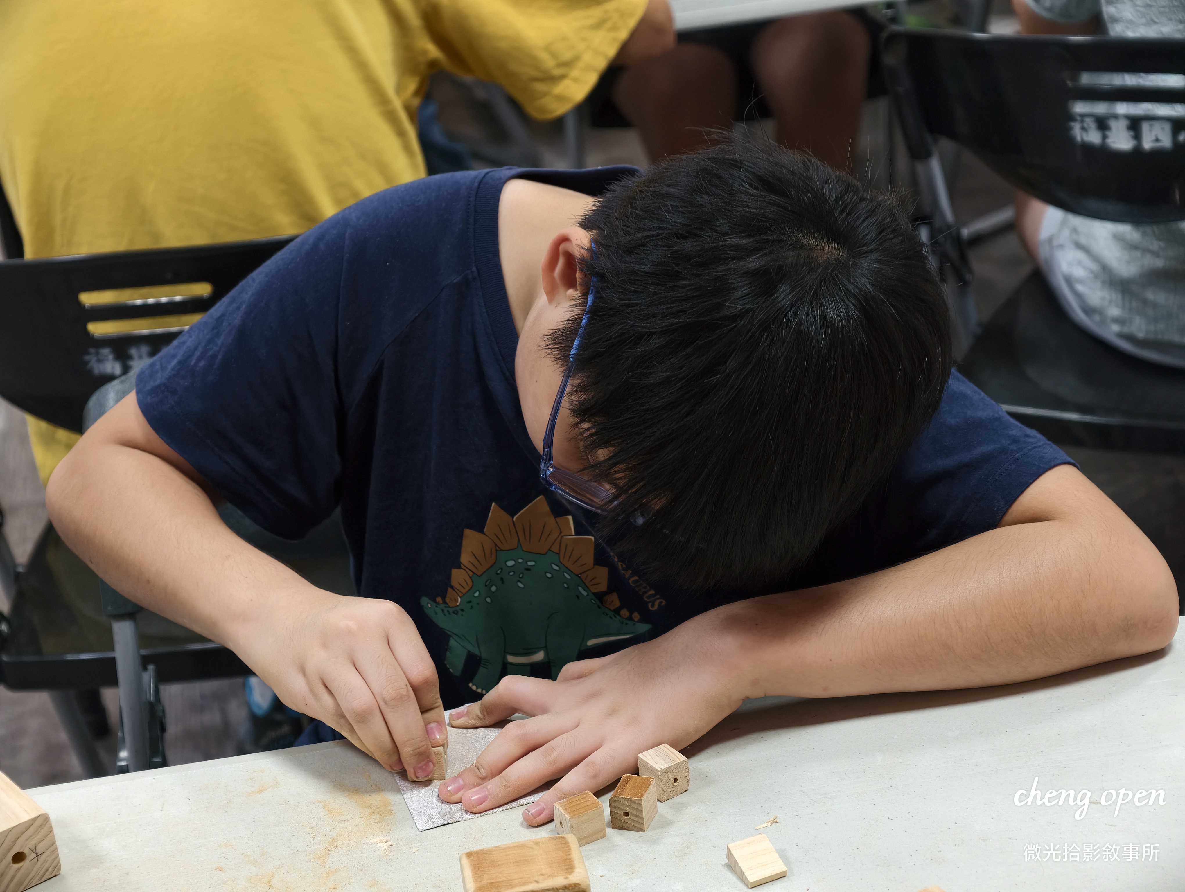 福基國小學童專注低頭使用砂紙細心打磨木育教具邊角