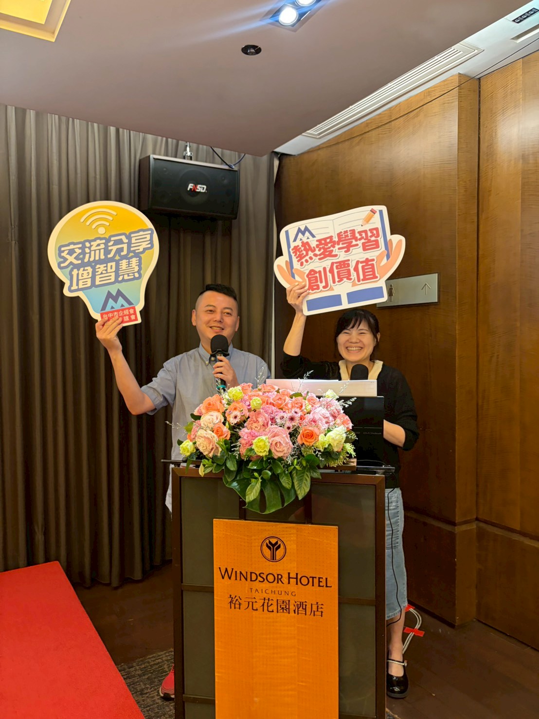 主持人與台中企經菁英聯誼會代表於會前高舉標語